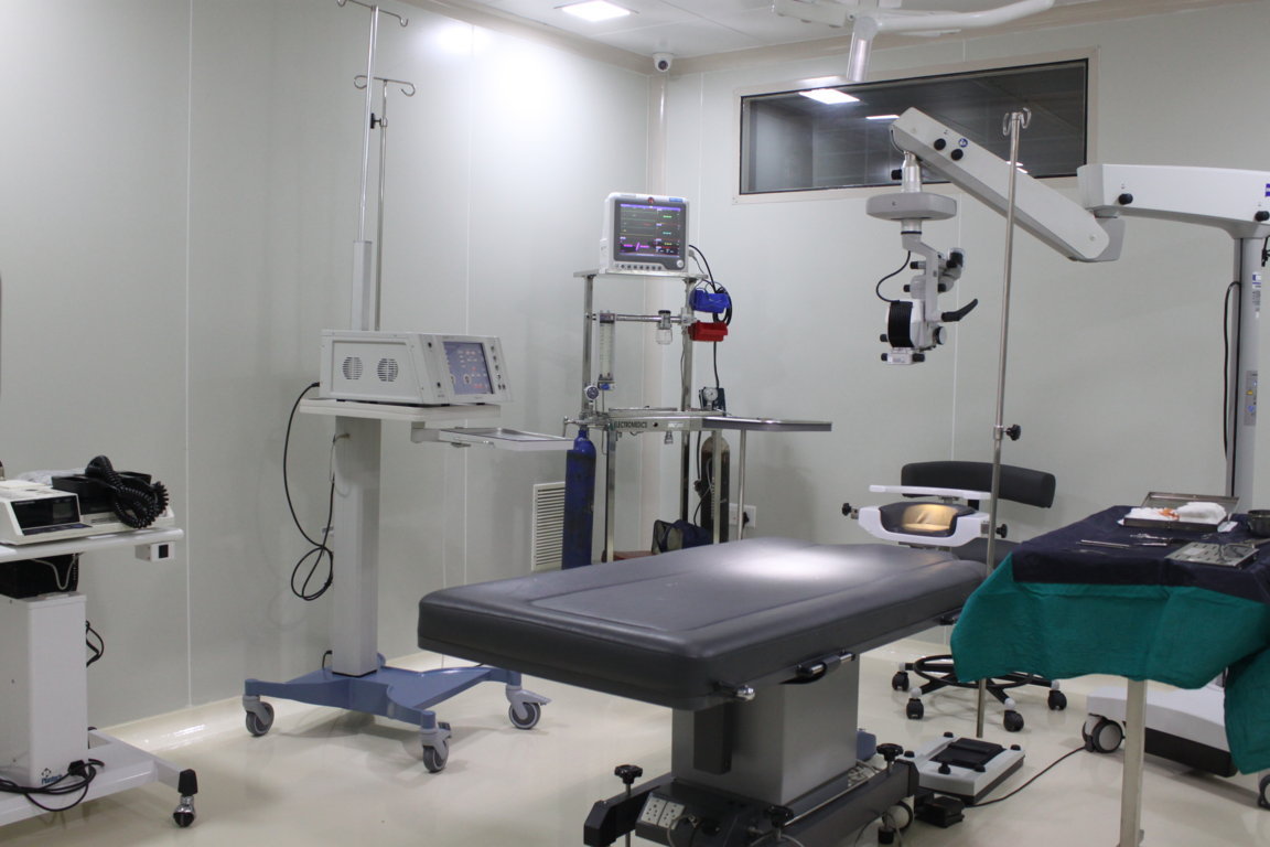Sterile modular operation theatre at Insight Institute with motorised patient table, surgeon's chair, vitals monitor and ceiling-mounted Zeiss microscope